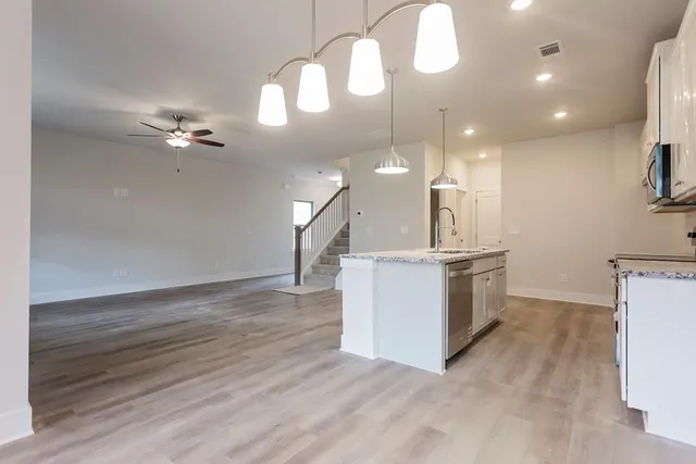 a view of a kitchen with sink and dishwasher with wooden floor