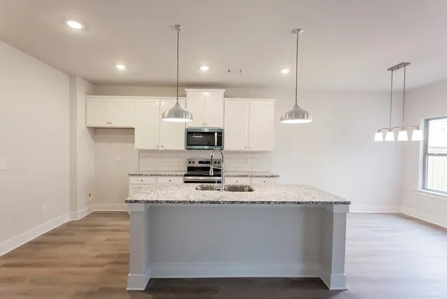 a kitchen with kitchen island a sink stainless steel appliances and window