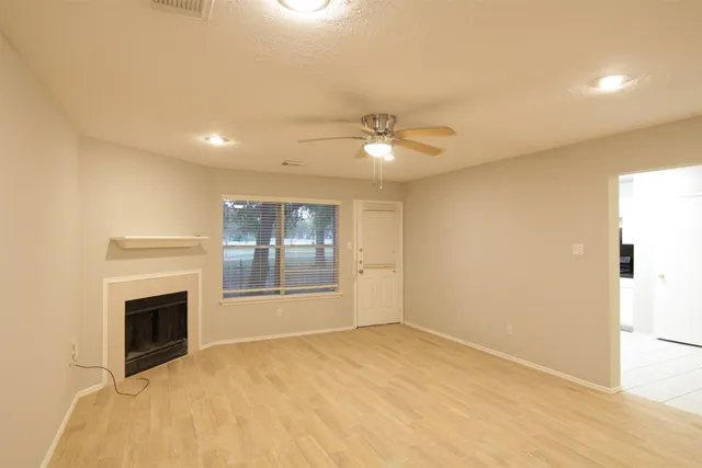 a view of an empty room with a fireplace and a window