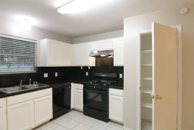 a kitchen with a sink and white cabinets