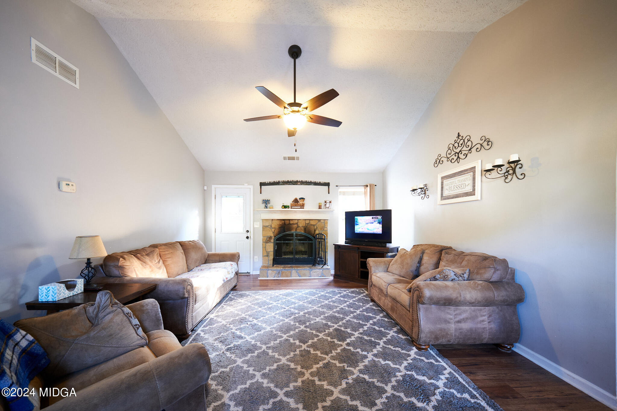 625 Windsor Drive Monroe, GA 30656 - Photo 7 of 27 a living room with furniture a fireplace and a chandelier