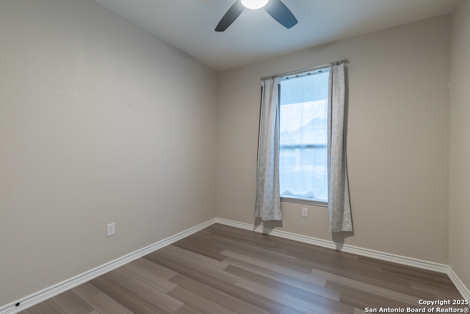8026 San Mirienda Boerne, TX 78015 - Photo 12 of 29 an empty room with wooden floor and windows