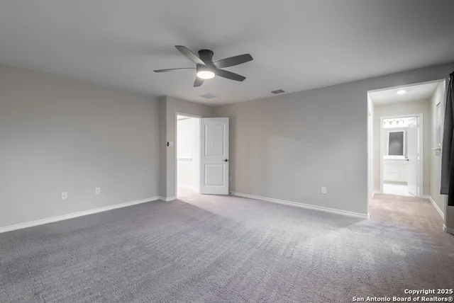 a view of an empty room with a ceiling fan