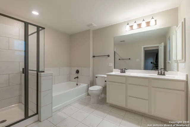 a spacious bathroom with a bathtub shower sink mirror and toilet