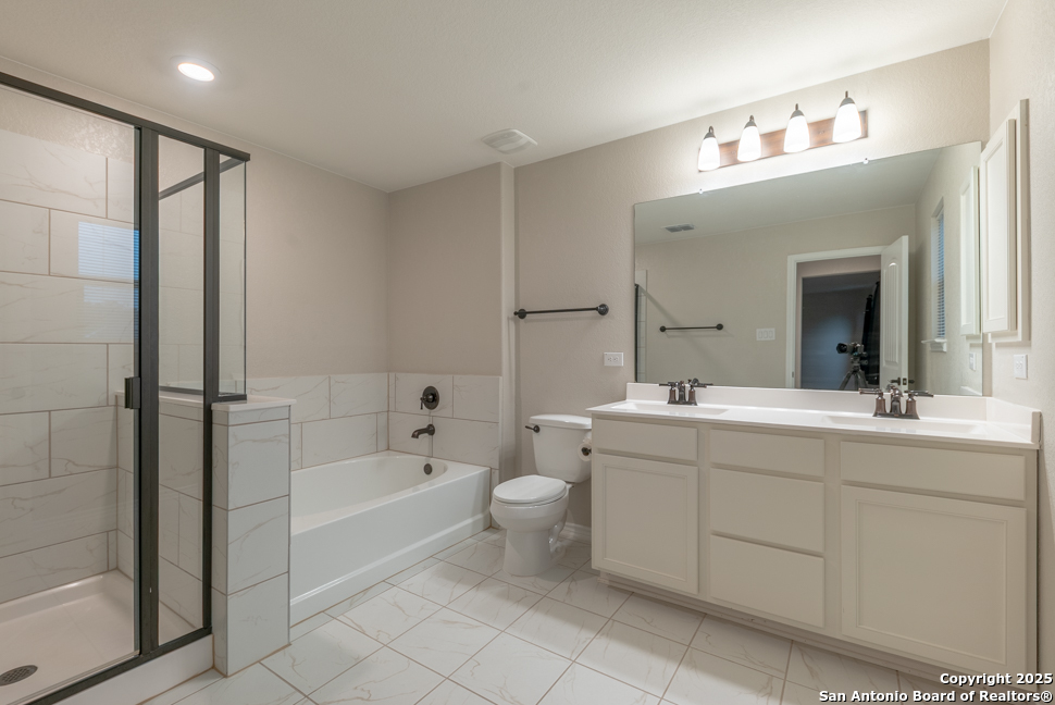 8026 San Mirienda Boerne, TX 78015 - Photo 19 of 29 a spacious bathroom with a bathtub shower sink mirror and toilet