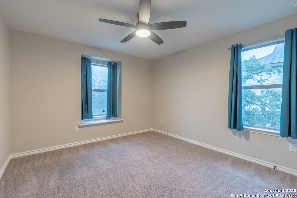 8026 San Mirienda Boerne, TX 78015 - Photo 20 of 29 an empty room with windows and fan