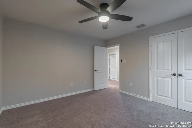an empty room with chandelier fan