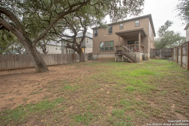 a view of a yard with a house and a large tree