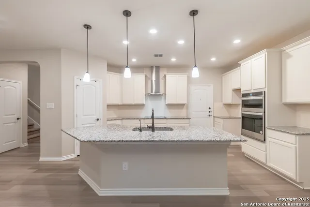 a large kitchen with kitchen island a large counter top stainless steel appliances and cabinets