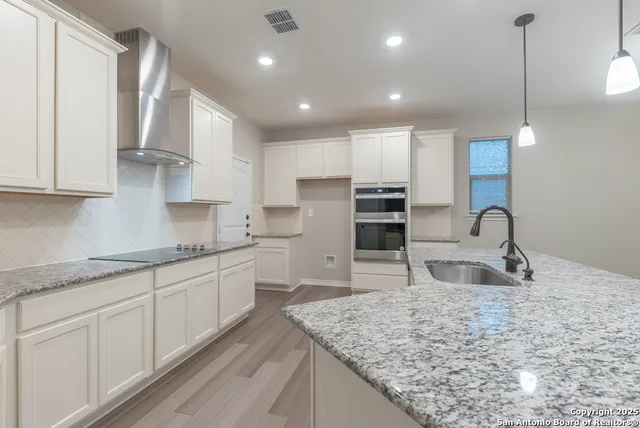 a kitchen with stainless steel appliances granite countertop a sink stove and cabinets