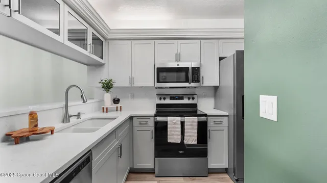 a kitchen with stainless steel appliances a stove microwave and sink