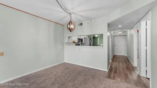 a view of a livingroom with wooden floor and kitchen space