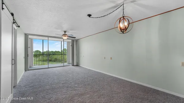 a view of a room with window and ceiling fan