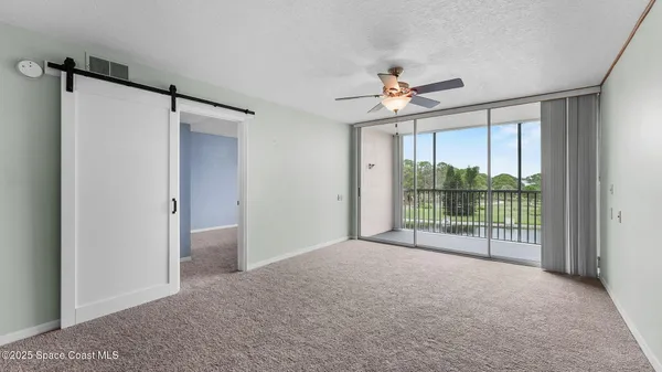 a view of empty room with windows and ceiling fan
