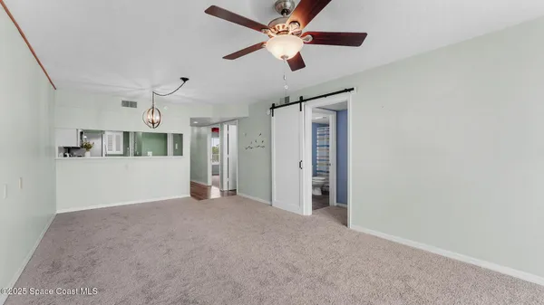 a view of a livingroom with a ceiling fan and window