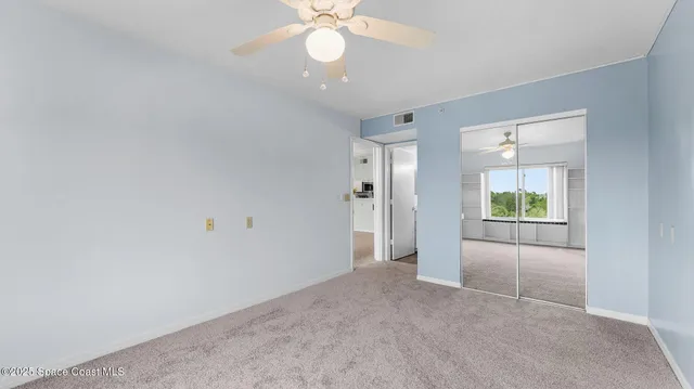 an empty room with fan and windows