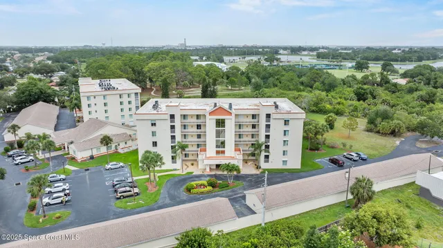an aerial view of a house with a garden and large trees