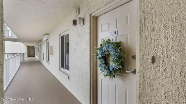 a view of a hallway with wooden floor and a living room
