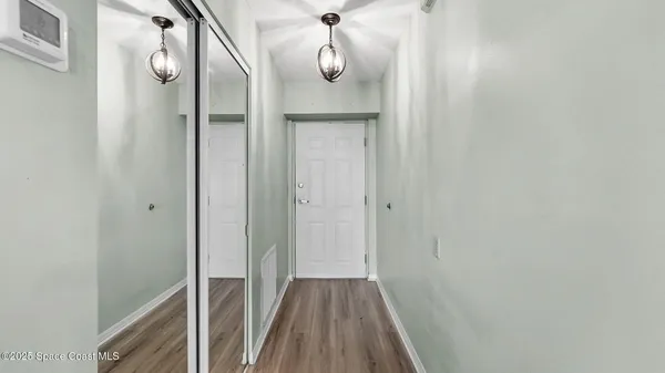 a view of a hallway with wooden floor