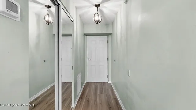 a view of a hallway with wooden floor