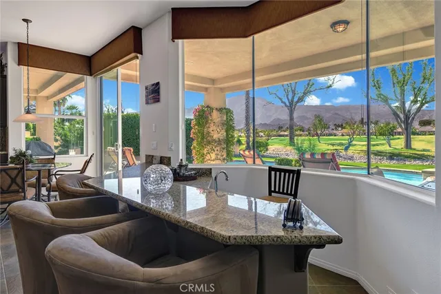 a kitchen with a table chairs and a large window