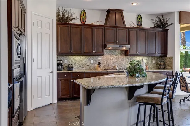 a kitchen with stainless steel appliances granite countertop a sink refrigerator and cabinets