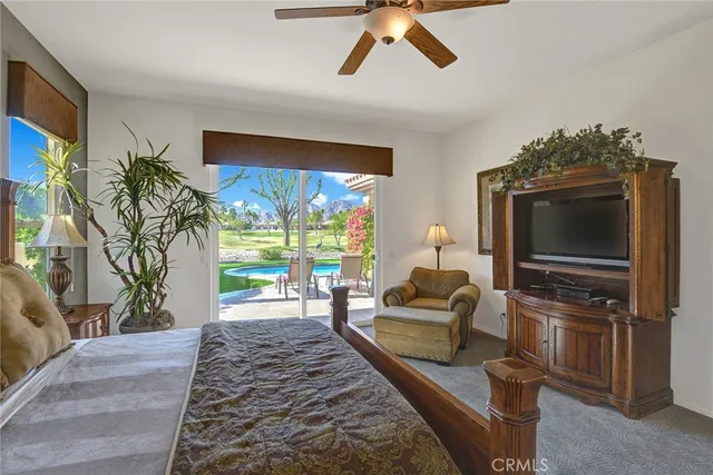 a living room with furniture a flat screen tv and a floor to ceiling window