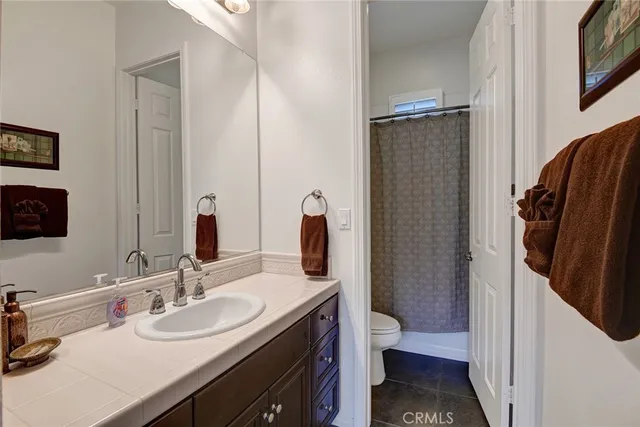a en suite bathroom with a granite countertop sink and a mirror