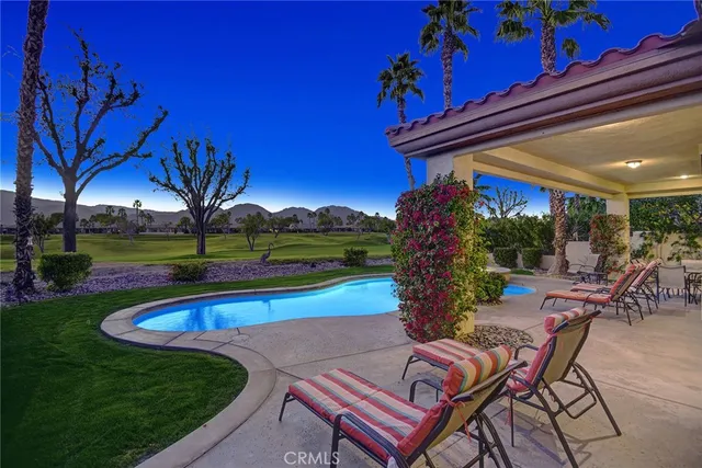 a swimming pool with outdoor seating and yard