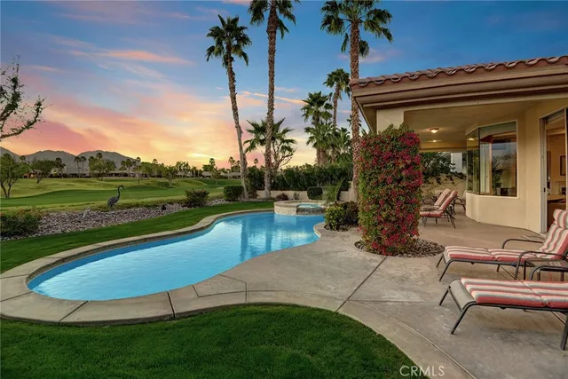 a view of a house with a swimming pool and a yard