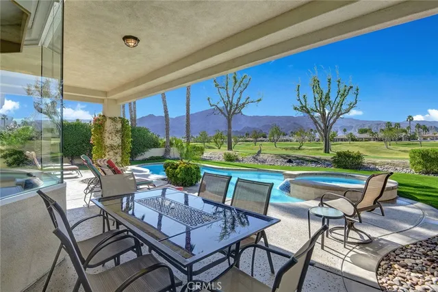 a view of a patio with a table chairs and a yard