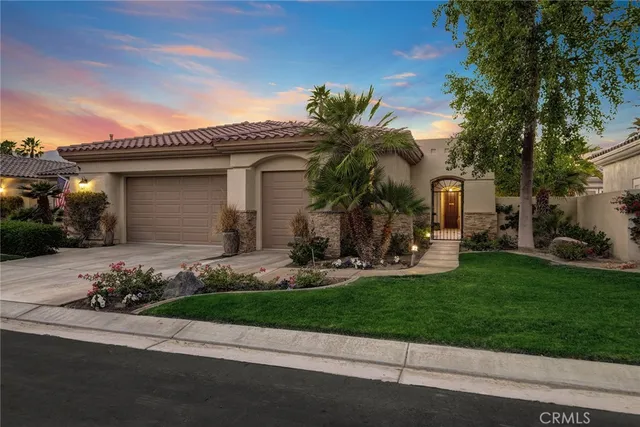 a front view of a house with garden and plants