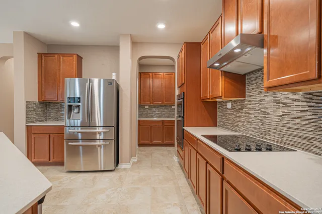 a kitchen with stainless steel appliances granite countertop a refrigerator and a sink