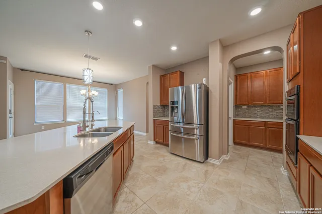 a large kitchen with granite countertop a refrigerator and a sink