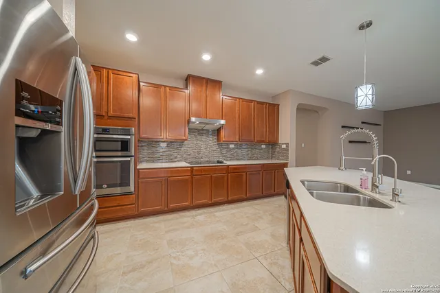 a kitchen with stainless steel appliances granite countertop a sink refrigerator and cabinets