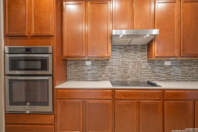a kitchen with granite countertop cabinets stainless steel appliances and a counter space