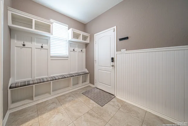 a view of a kitchen with white cabinets and entryway
