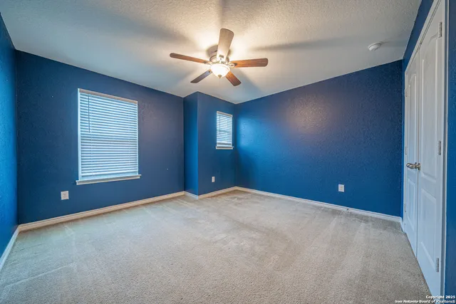 an empty room with closet and fan