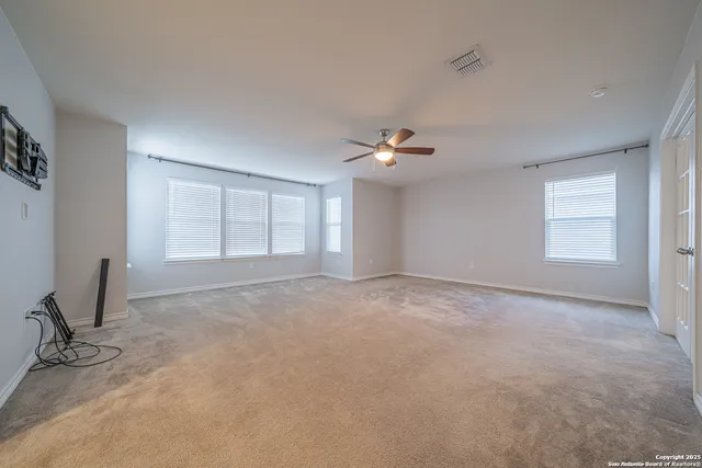 a view of an empty room with a ceiling fan
