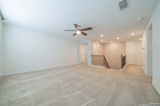 a view of an empty room with a ceiling fan