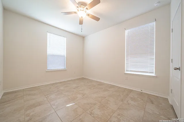 an empty room with a window and a fan