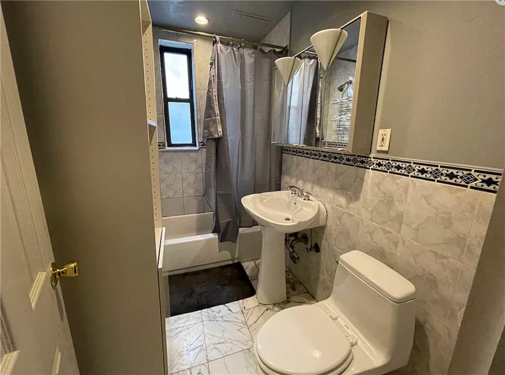 411 88th Street Brooklyn, NY 11209 - Photo 3 of 7 a bathroom with a sink a toilet and shower