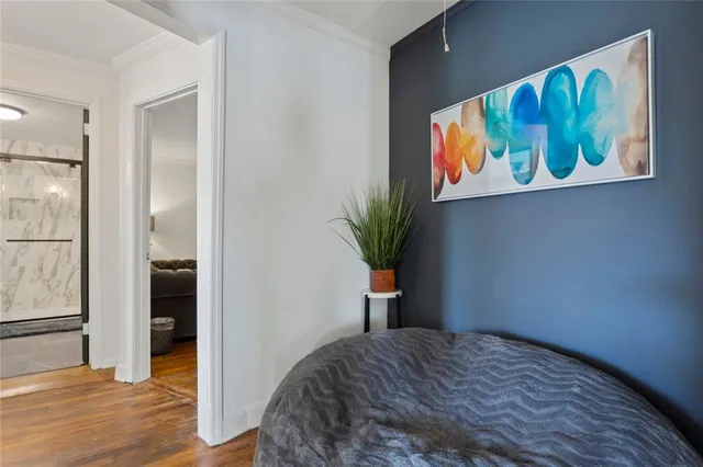 a spacious bedroom with a bed couch chandelier and a window