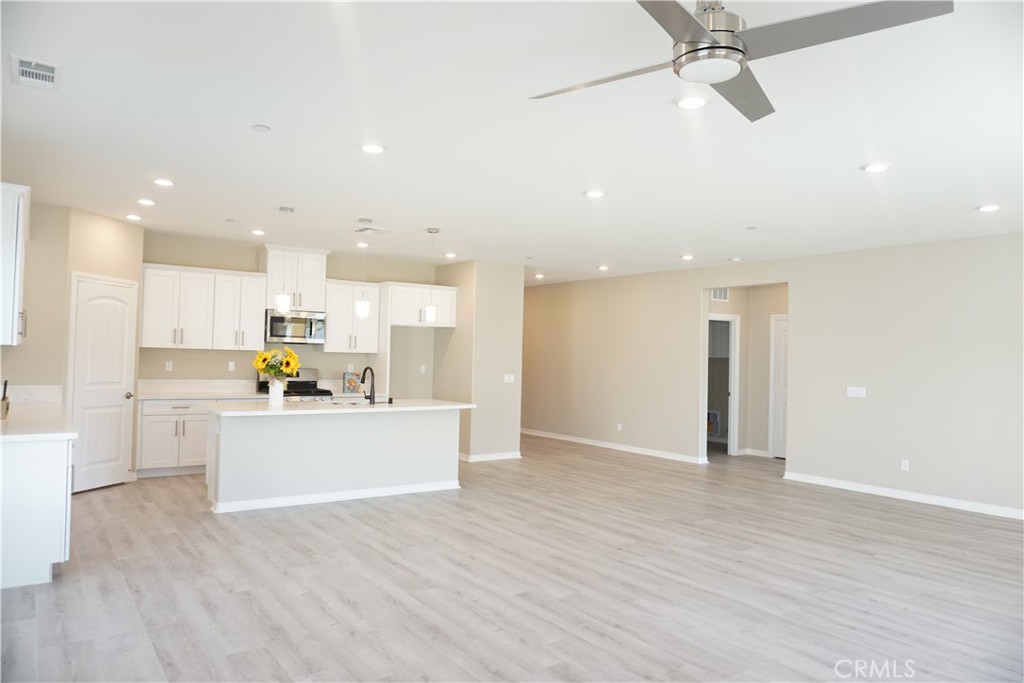 128 Chumash Perris, CA 92570 - Photo 10 of 22 a view of a kitchen with kitchen island a sink wooden floor and stainless steel appliances