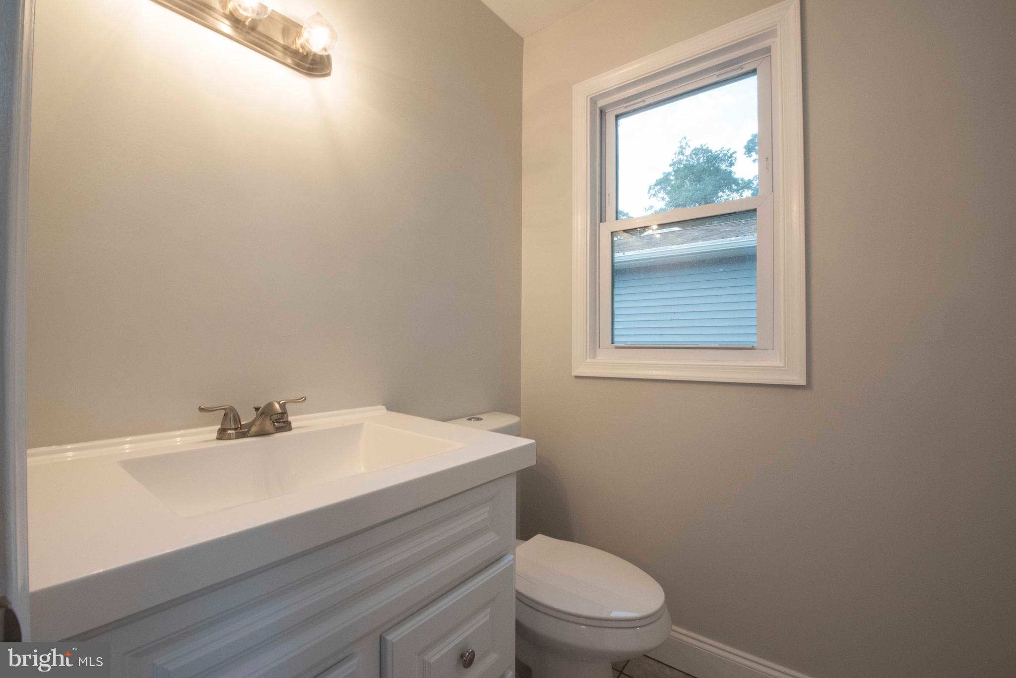 1808 Glenarm Road Edgewater, MD 21037 - Photo 13 of 29 a bathroom with a sink a toilet and a window