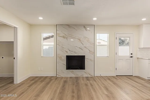 an empty room with windows and fireplace