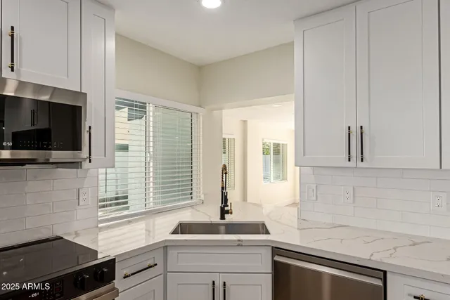 a kitchen with stainless steel appliances a sink stove and cabinets