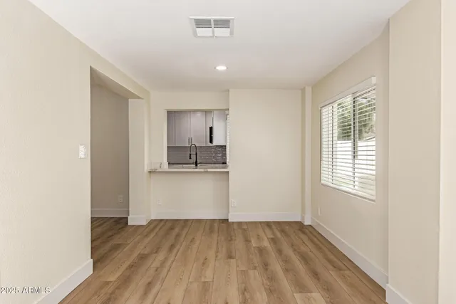 a view of empty room with wooden floor and window