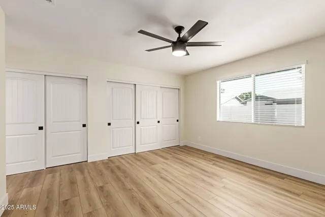 a view of a big room with wooden floor closet and windows