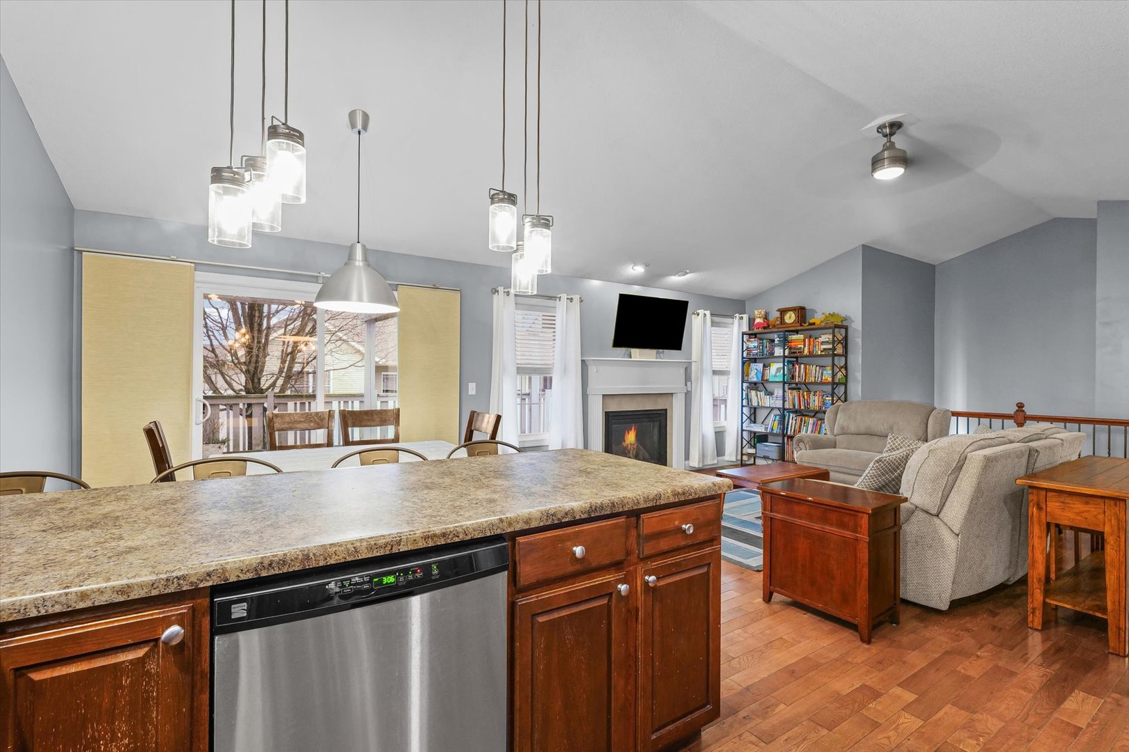 1713 Hunters Ridge Court Mahomet, IL 61853 - Photo 12 of 30 a living room with stainless steel appliances kitchen island granite countertop a table chairs in it and a wooden floor
